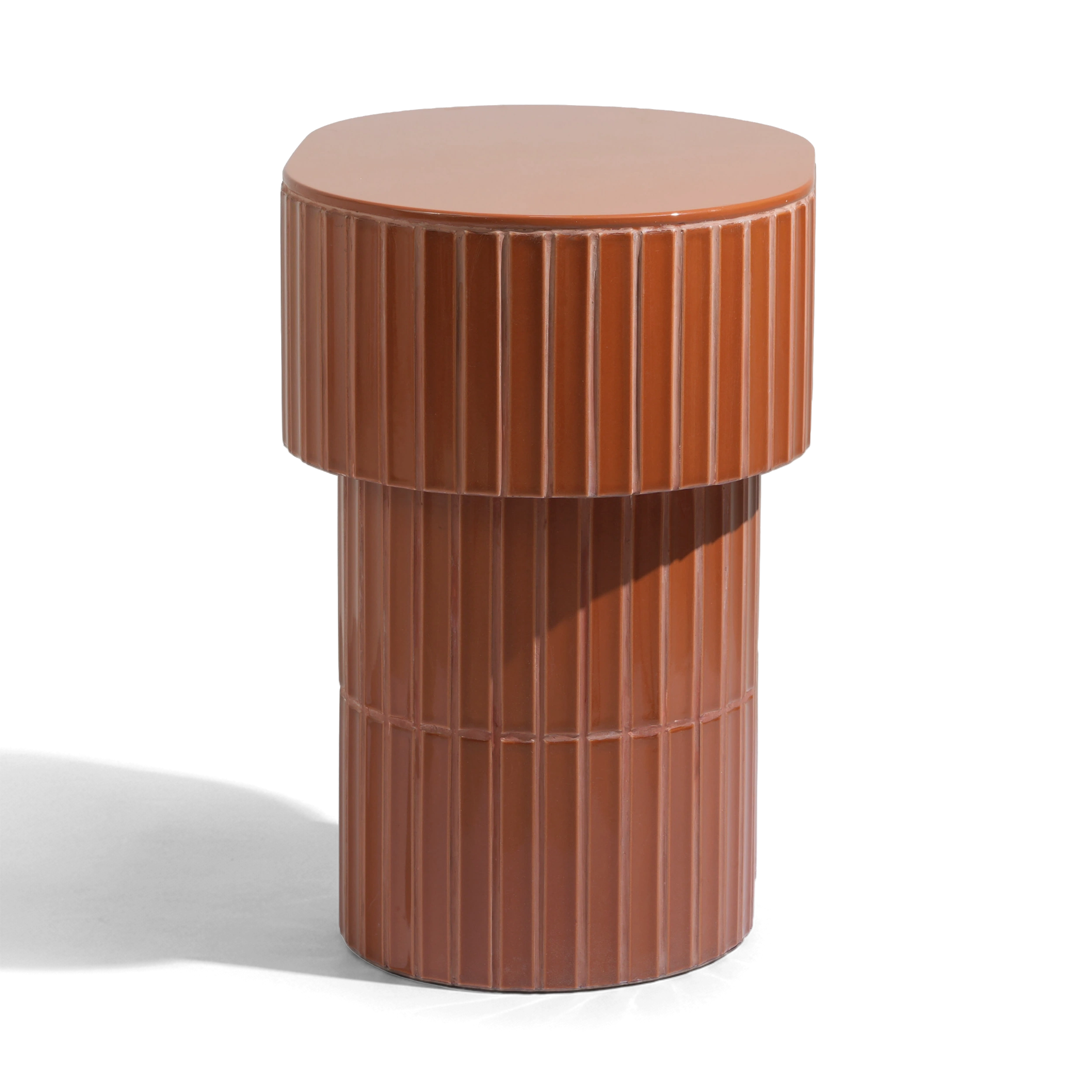 A modern oval side table or stool with a grooved ceramic tiled finish featuring a round top and a warm brown color, shown on a plain background.