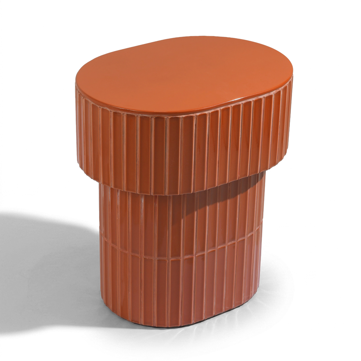 A modern oval side table or stool with a grooved ceramic tiled finish featuring a round top and a warm brown color, shown on a plain background.