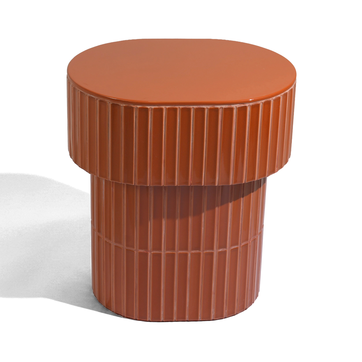 A modern oval side table or stool with a grooved ceramic tiled finish featuring a round top and a warm brown color, shown on a plain background.
