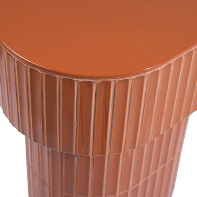 Close-up of a brown-colored side table showing the smooth rounded top and tiled pedestal base.